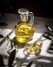 A clear glass pitcher filled with golden olive oil, infused with fresh rosemary sprigs, sits