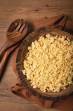 Cooked couscous, in a wooden bowl, top view, no people
