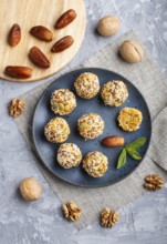 Energy ball cakes with dried apricots, sesame, linen, walnuts and dates with green mint leaves on a