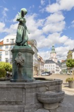 Pigeon girl on the Schlegel fountain in front of the town hall, in the background the Nicolai
