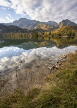 On the shore of Lake Lake Kochel with reflection, autumn landscape with mountain peaks Herzogstand