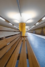 Modern underground station with yellow columns and bright lighting, Hamburg, Germany