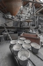 Bucket with zinc flakes in the production room with the metal powder grinding mill for the