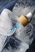 A rejuvenating face care serum or oil for men, presented in a stylish dropper bottle encased in ice