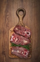Raw steak, calf's neck on the bone, fresh meat, on the cutting board, top view, no people