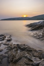 Sunset over crystal clear water on the beach of Ustrine Bay on the island of Cres, long exposure,