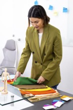 A professional image consultant in an office setting carefully selects vibrant fabrics for a
