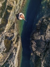 Top view of an unrecognizable woman floating on an inflatable in the clear, waters of a natural