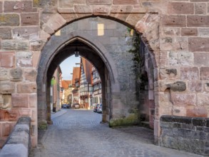 Alley with cobblestones leads through the town gate Oberes Tor, view through the gate to the