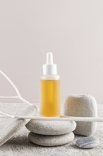 A luxury skincare oil bottle with a dropper, nestled among smooth stones Minimalist aesthetic with