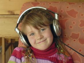 Portrait of a little girl, 6 years old with headphones, Franconia, Bavaria, Germany