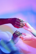 Multiethnic hands gently holding each other with vibrant colored lighting in the background,