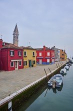 Colorful houses beside the waterway at 'Fondamenta di Pizzo' with boats lying in the water on the