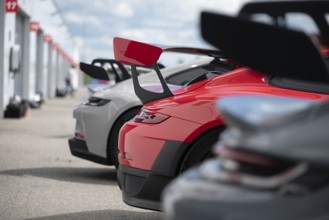 A lineup of high-performance sport cars with prominent rear wings, showcasing advanced aerodynamics