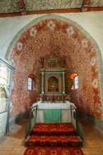 Interior and altar, walls with colourful frescoes in the Romanesque fieldstone church in the
