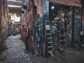 Narrow alley with cobblestones and a workshop, bustling urban atmosphere, small, dark workshop full