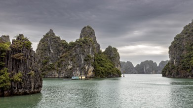 Limestone cliffs and small boats on calm waters under a cloudy sky, The landscape and islands of