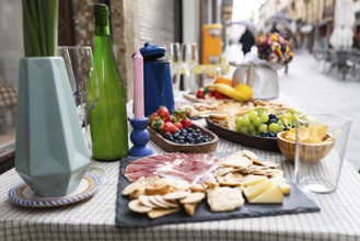 Elegant outdoor dining setup with a delightful charcuterie board, fresh fruit, and beverages.