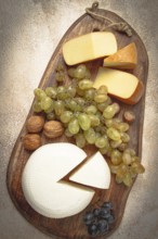 Georgian cheese, Imeretian and smoked suluguni, grapes, nuts, on a cutting board, Georgian cuisine,