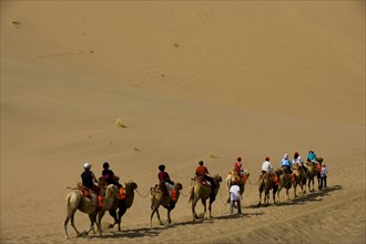 A Group of People Riding Camels in the Desert