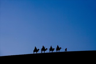 A Group of People Riding Camels in the Desert