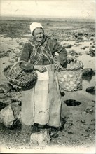 Vieille femme ramassant des moules