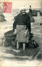 Vieille femme ramassant des moules