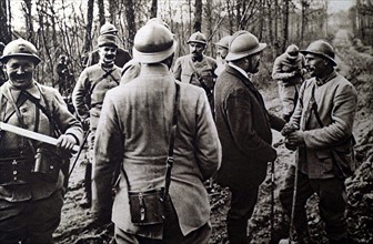 Première Guerre Mondiale. Sur le front de l'Argonne, un soldat offre à M. Barthou un bouquet de primevères