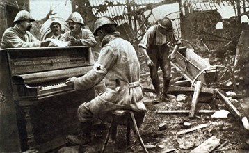 Première Guerre Mondiale. Dans un village de la Somme, soldat français jouant du piano au milieu des décombres (1916)