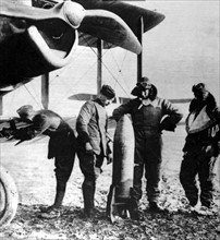 World War I. British aviators loading large torpedos on their plane