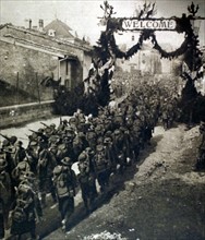 World War I. An American battalion marching through a village in the Meuse on its way to the front