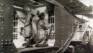 Première Guerre Mondiale. En Angleterre, des femmes peignant l'intérieur d'un tank