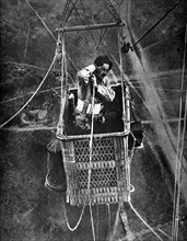 Première Guerre Mondiale. L'observateur d'un ballon captif dit "Saucisse" téléphonant ses observations et vérifiant les attaches de son parachute