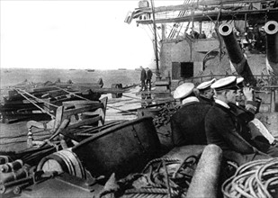Première Guerre Mondiale. A l'entrée des Dardanelles, un cuirassé anglais avance, paré pour le combat, dans la ligne des chalutiers relève-mines devant Seddul-Bahr