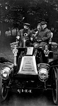 Tristan Bernard behind the wheel of a Renault car, Jules Renard sitting next to him and at the back, Lucien Guitry's son, Sacha (early 20th century)
