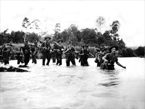 Soldats australiens traversant un fleuve en Nouvelle-Guinée, 14 juin1944