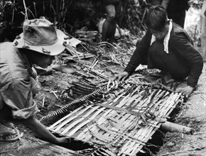 South Vietnam guerilleros setting up a trap.