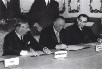 October 1954, London and Paris agreements. Adenauer, surrounded by Eden and Mendès-France, signs the agreement on rearmament and German sovereignty.