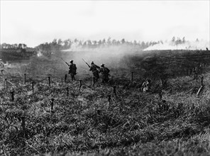 Soldiers from the American infantry advancing behind a tank near Beauquesnes