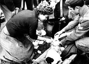 Queen Frederika treating soldiers injured during the war