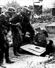 Stalingrad. Des soldats allemands découvrent une vieille femme russe dans une cachette (1942)