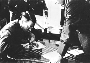 Hitler signant un papier concernant le protectorat Bohème-Moravie au Hradschin de Prague.