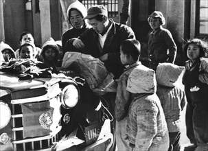 1950-1953, Guerre de Corée, orphelins rassemblés autour de la jeep des Nations Unies pour inspecter le contenu de paquets envoyés par des enfants étrangers