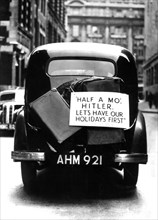 Londres. Automobile portant un écriteau : "Attends un peu Hitler, nos vacances d'abord"