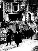 Le président Poincaré parcourant les rues d'une ville bombardée