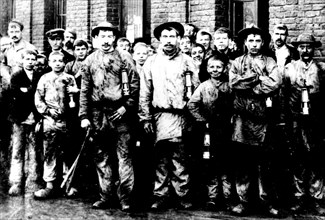 Groupe d'enfants et d'hommes travaillant dans la mine de Denain