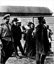 Russian revolutionaries leaving for Siberia. A woman sticks out her tongue at the photographer. A man holds a bouquet that a friend gave him