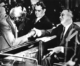 A l'institut Tuskegee, école noire fondée par Booker T. Washington, Roosevelt serre la main du professeur G.W. Carver, éminent homme de science dans le domaine de l'agriculture