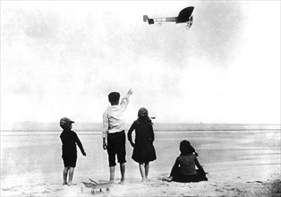Blériot crossing the English Channel. Children following Blériot's flight on the English coast