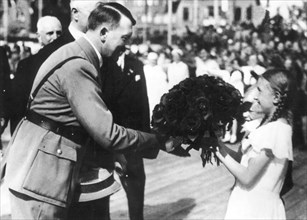 April 20, 1936, a young girl is offering Hitler a bunch of flowers for his 47th birthday